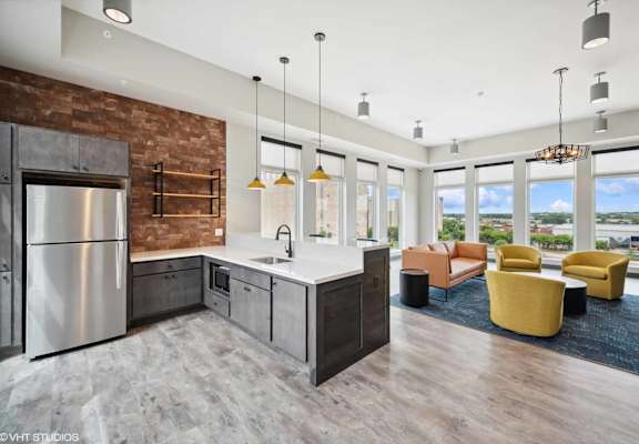 a kitchen with a large center island with a sink and a stove top oven