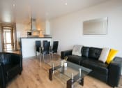 Thumbnail 3 of 3 - a living room with black leather furniture and a glass table