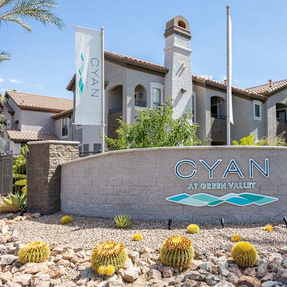 A sign that says "Cyan" is in front of a building.