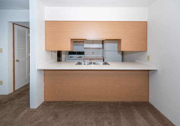 a dining room and kitchen with a table and chairs