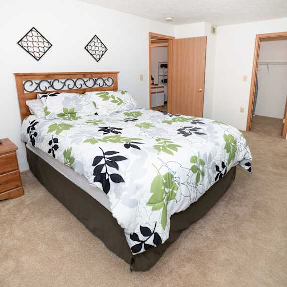 a white bedroom with a large bed and a window