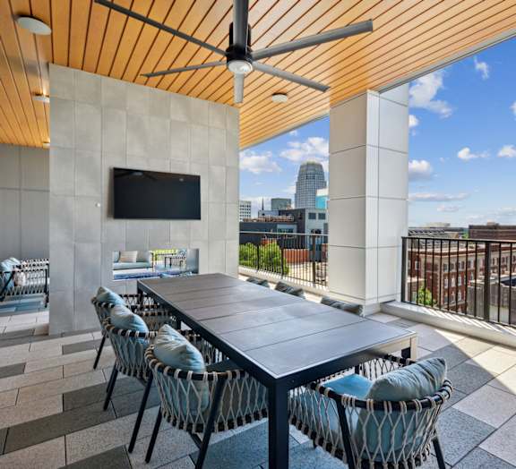 A patio with a table and chairs and a TV on the wall.