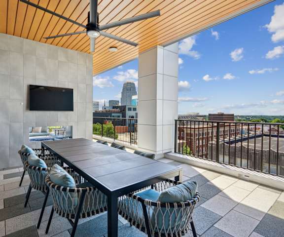 A patio with a table and chairs and a TV on the wall.