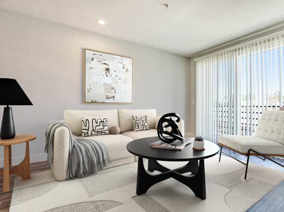 A living room with a white couch and a black coffee table.