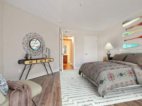 A bedroom with a bed, a chair, and a clock on the wall.
