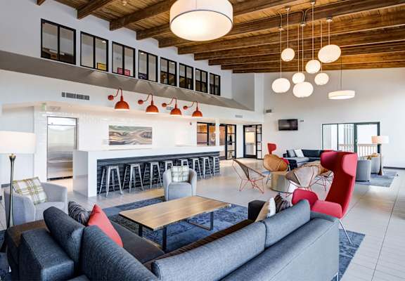 A modern living room with a grey couch and a wooden coffee table.