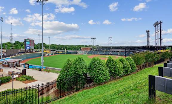 an aerial view of a baseball stadium with a green field and trees
