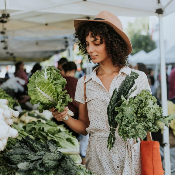 a woman holding vegetables at a farmers market at Salish Flats APARTMENTS, Airway Heights, WA 99001
