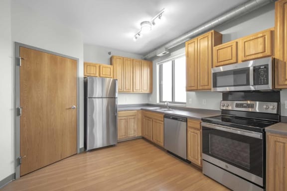a kitchen with wooden cabinets and stainless steel appliances