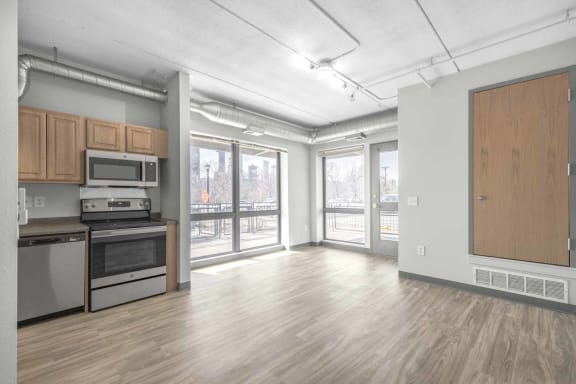 an empty living room with a stove and microwave