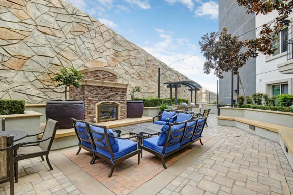 A patio with a stone wall and a fireplace. at Apex Mission Valley, San Diego, 92108
