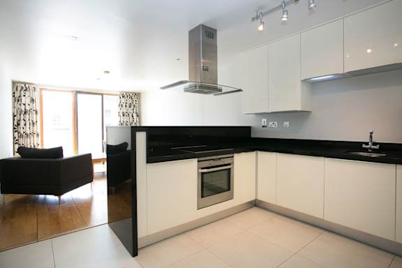 a kitchen with white cabinets and a black counter top