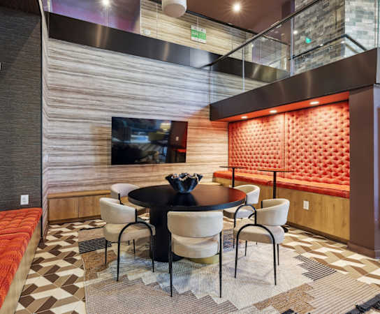 a dining area with a table and chairs and a television at Link Apartments® Broad Ave, Memphis, Tennessee