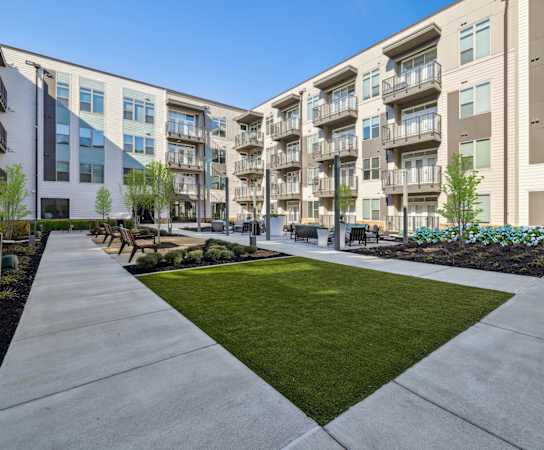 an exterior view of an apartment building with a sidewalk and grass at Link Apartments® Broad Ave, Memphis, Tennessee