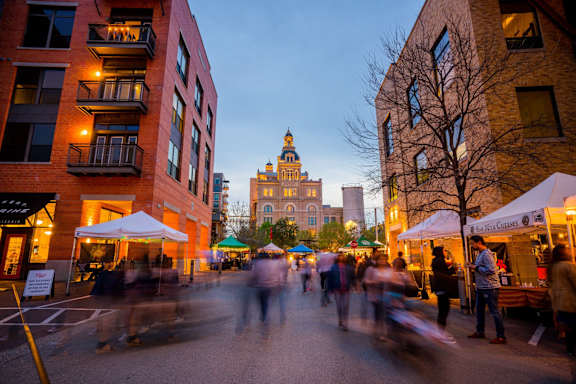 a crowd of people walking down a city street at night