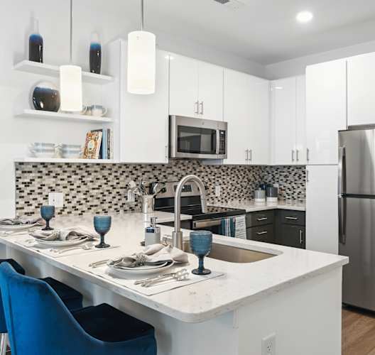 a kitchen with a island and a stainless steel refrigerator  at Link Apartments® Mint Street, Charlotte, North Carolina