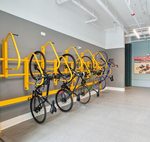 a room with several bikes hanging on a wall and a bathroom with sinks  at Link Apartments® Mint Street, Charlotte, North Carolina