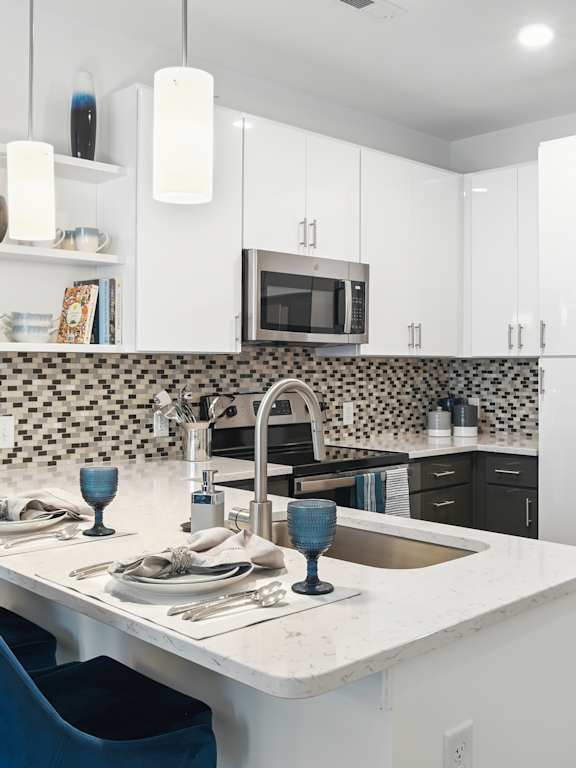 a kitchen with a island and a stainless steel refrigerator  at Link Apartments® Mint Street, Charlotte, North Carolina