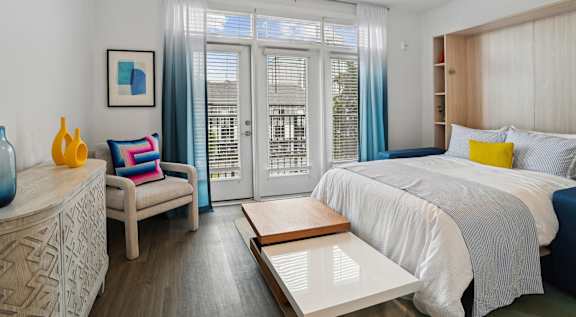 a bedroom with a bed and a sliding glass door  at Link Apartments® Mint Street, Charlotte, North Carolina