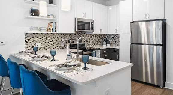 a kitchen with a island and a stainless steel refrigerator  at Link Apartments® Mint Street, Charlotte, North Carolina