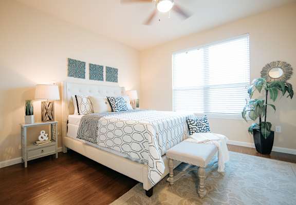 A bedroom with a large bed and a bench in front of it.