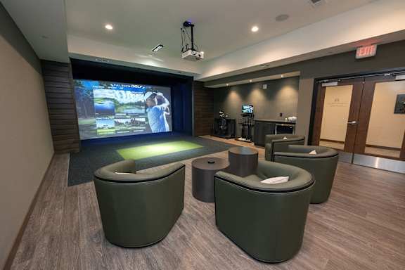 a room with a large screen and a bunch of chairs