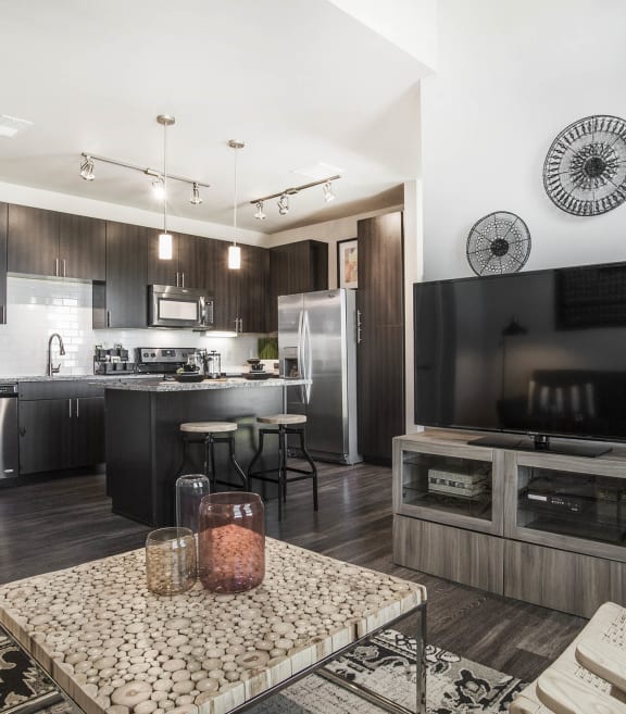 a living room and kitchen with a table and a tv