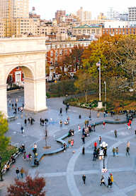 A large open plaza with a fountain and people milling about.