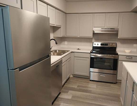 A kitchen with a stainless steel refrigerator and a stainless steel oven.