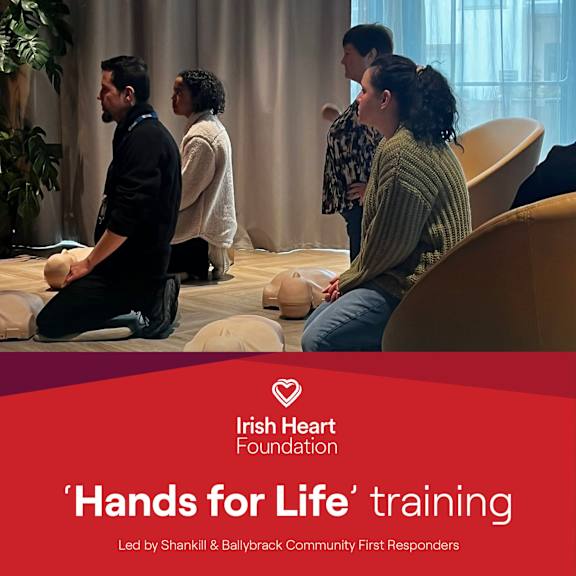 A group of people are sitting on exercise balls in a room for a 'Hands for Life' training led by Shankill & Ballybrack Community First Responders.