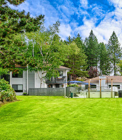 a large grassy area with houses in the background