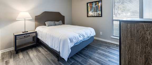 A bedroom with a bed, nightstand, and a ceiling fan.