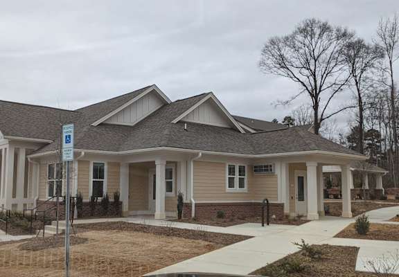 a house with a porch and a sidewalk in front of it