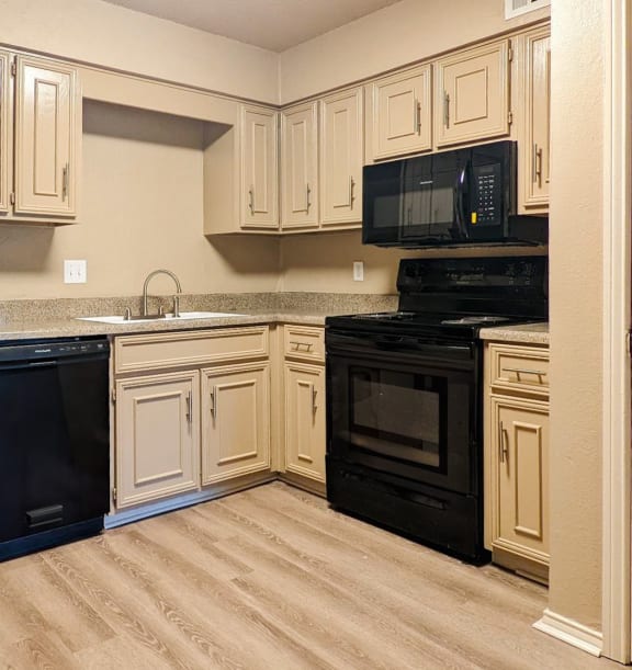 a kitchen with white cabinets and black appliances