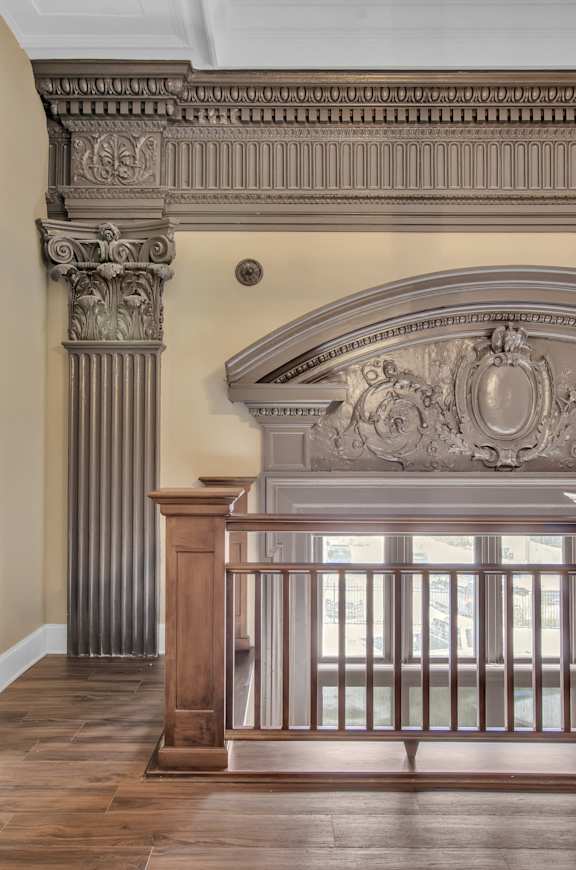 A balcony with a railing and a column with a decorative capital. at The Knights @ 506 Delaware Apartments, Buffalo, NY