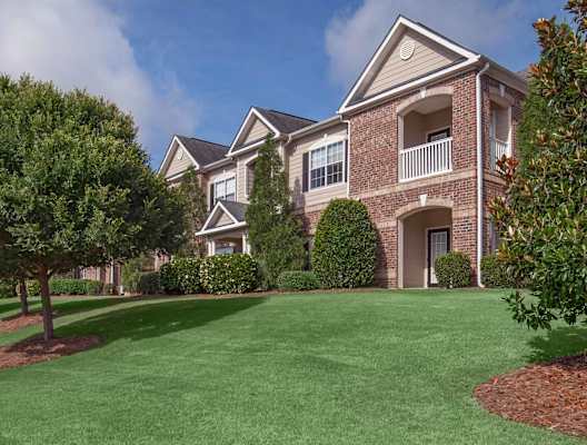 A large house with a green lawn in front.at Carrington Place at Wildewood, South Carolina