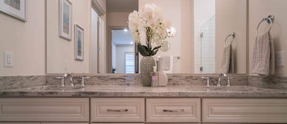 A luxurious bathroom with a double vanity, marble countertop, and elegant decor.