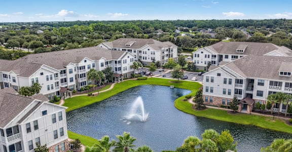 A large white building with a fountain in front of it at Terraces at Town Center, Jacksonville, FL