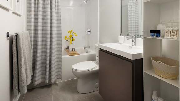 A bathroom with a toilet, sink, and shower.