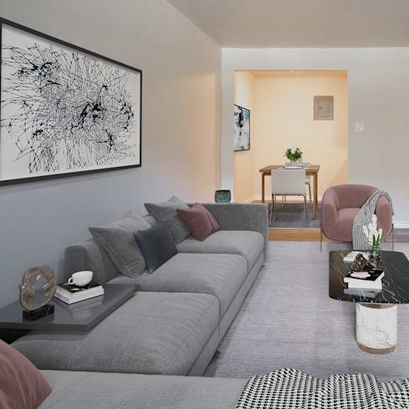 A living room with a grey couch, a round table, and a television.