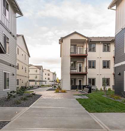 A bicycle is parked on a sidewalk in a residential area at Woodburn Place Apartment Homes, Woodburn, OR, 97071