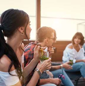 A group of people are sitting on a patio enjoying drinks.