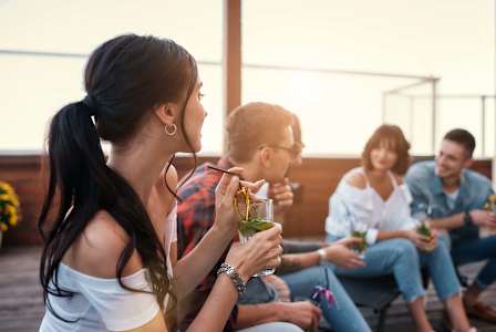 A group of people are sitting on a patio enjoying drinks.