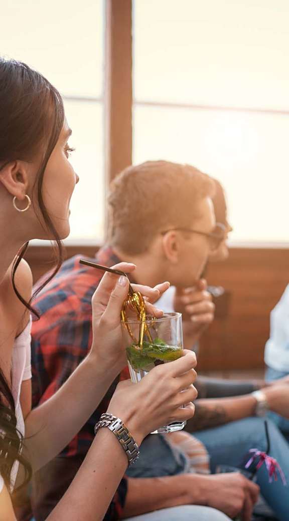 A group of people are sitting on a patio enjoying drinks.