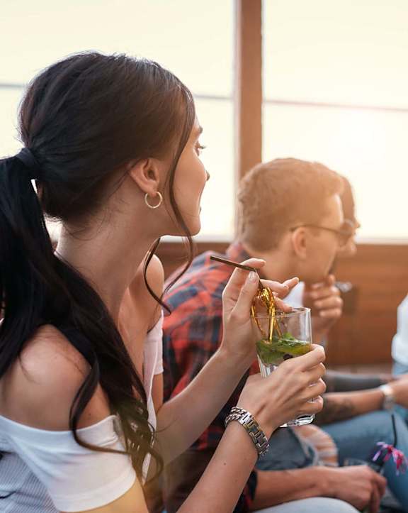 A group of people are sitting on a patio enjoying drinks.