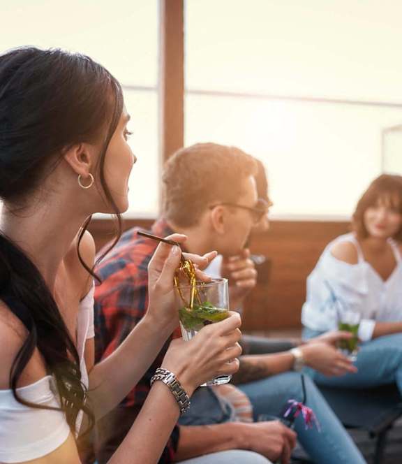 a group of people sitting around eating and drinking