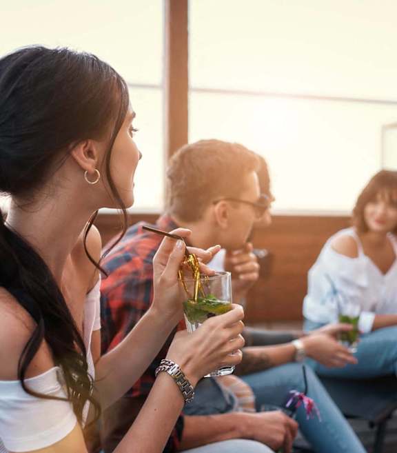 A group of people are sitting on a patio enjoying drinks.
