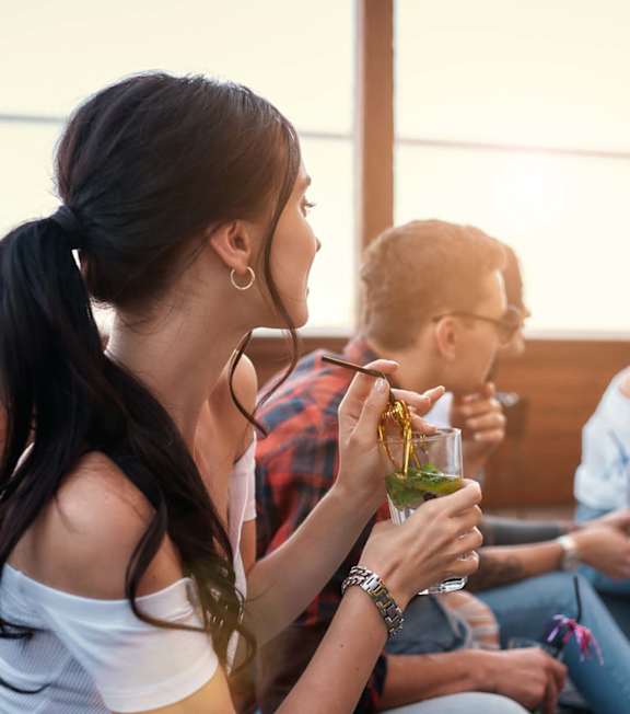 A group of people are sitting on a patio enjoying drinks.