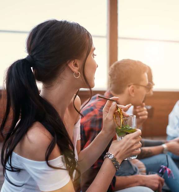 A group of people are sitting on a patio enjoying drinks.