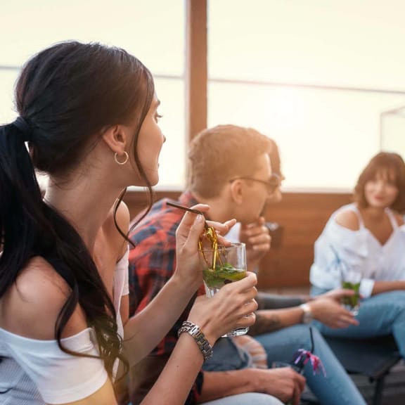 a group of people sitting around eating and drinking